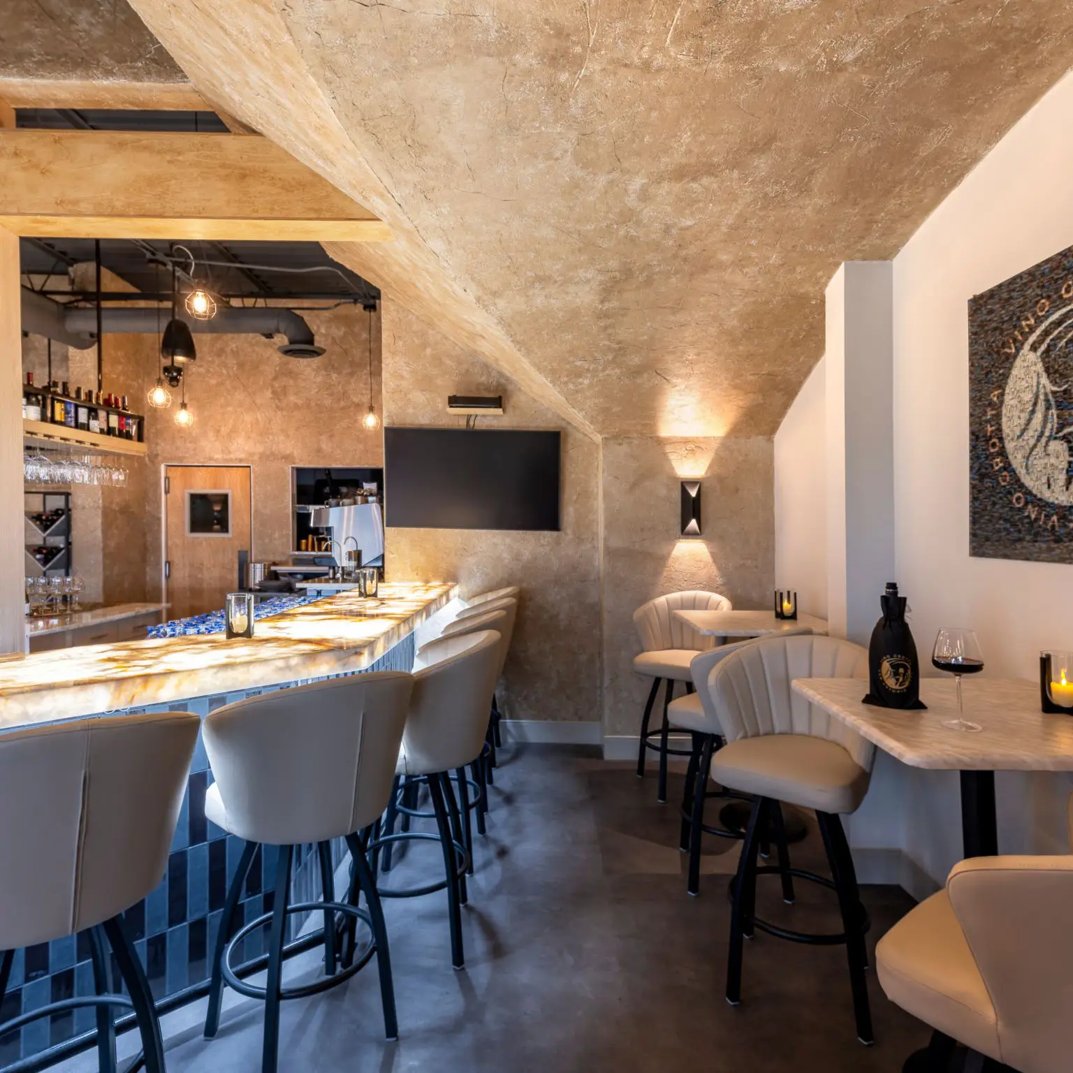 Restaurant bar seating and high-top tables beneath sculptural plaster ceiling