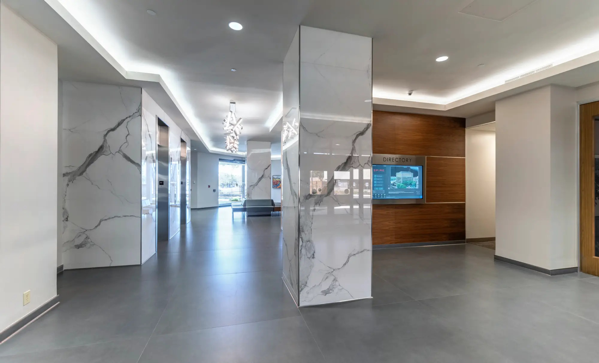 Building lobby with marble-clad columns and digital directory screen