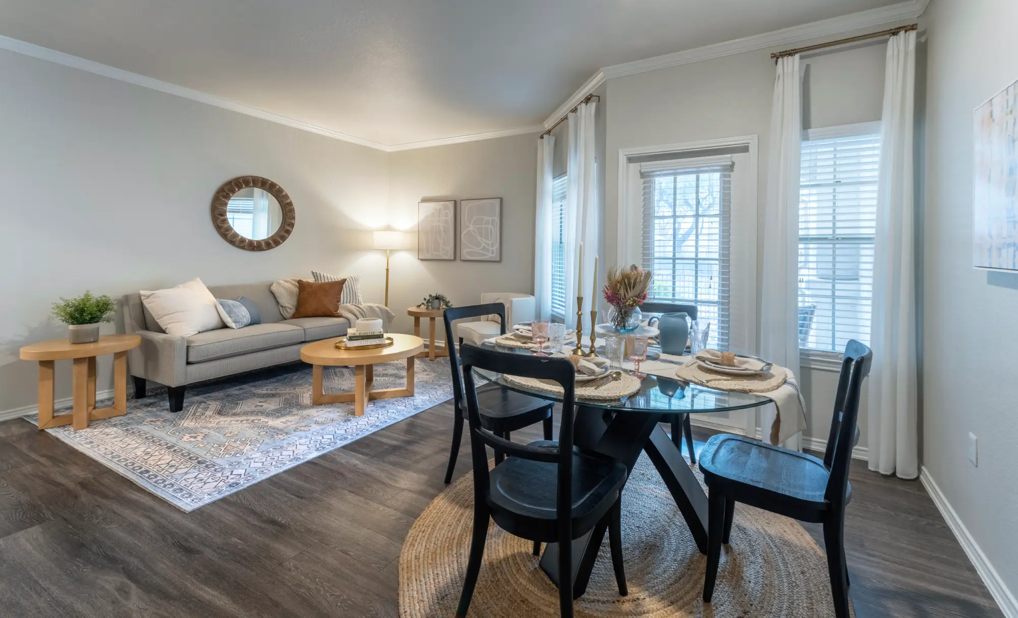 Apartment living and dining room with glass dining table and gray sofa