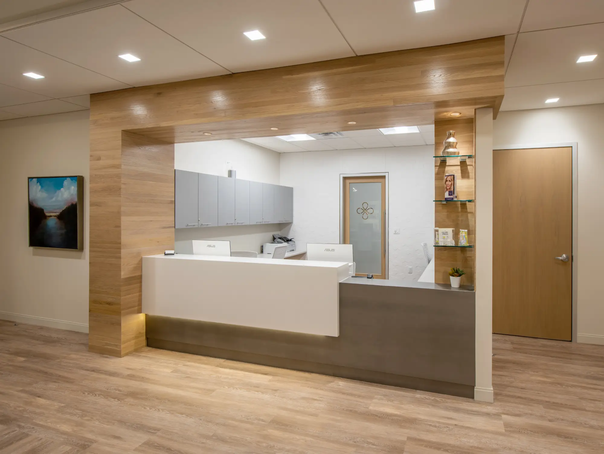 Medical spa reception desk framed by wood-clad archway with product display shelves